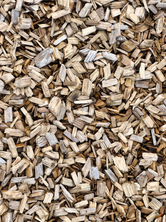 A detailed, overhead shot reveals a dense spread of various wood chips, offering an organic and...