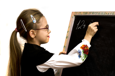 schoolgirl wrote on the blackboard isolated on a white backgroundの写真素材