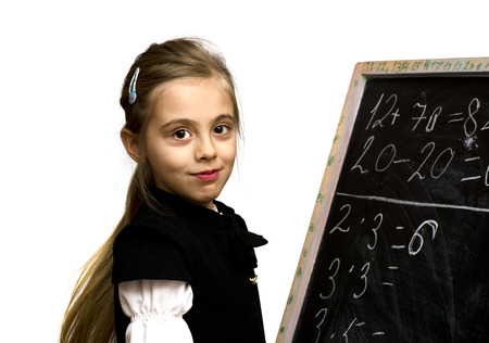 smiling schoolgirl standing near the blackboard isilated on a white backgroundの写真素材
