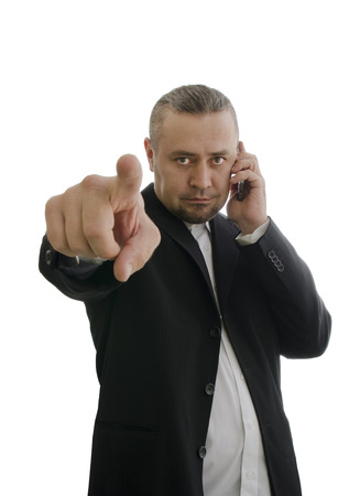 businessman in a jacket shows the index finger and talking on a cell phone isolated on white backgroundの写真素材