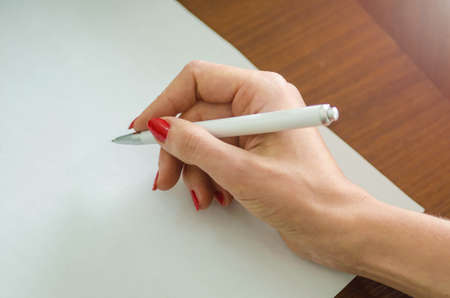 girl with a pen in her hand and a piece of paperの写真素材