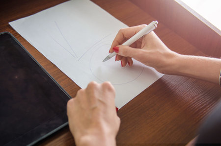 girl with a pen in her hand and a piece of paperの写真素材