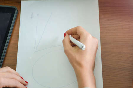 girl with a pen in her hand and a piece of paperの写真素材