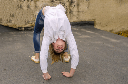 the girl is engaged in gymnastics in the streetの写真素材