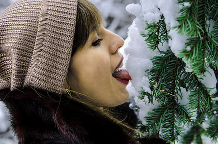 girl licking the first snow from the Christmas tree