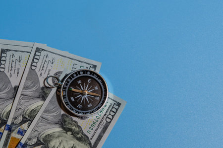 compass on pile of dollar bills usning as travel concept or world economics fortune direction.