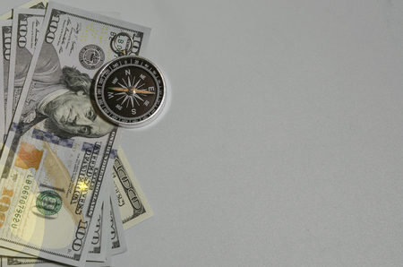 compass on pile of dollar bills usning as travel concept or world economics fortune direction.の写真素材