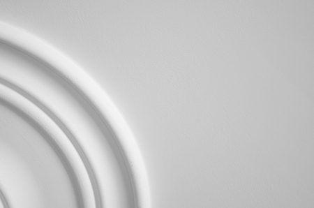 Round decorative clay stucco relief molding on white ceiling in abstract classical style interiorの写真素材