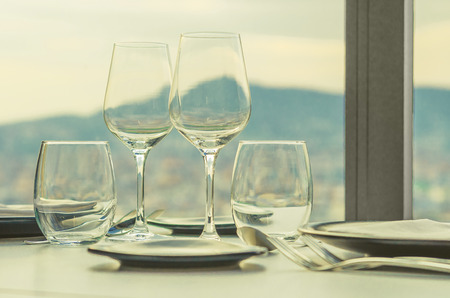 glasses and cutlery on the restaurant table with a view of the city of Barcelonaの写真素材