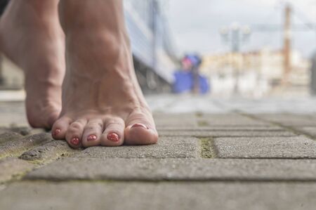 barefoot girl  is standing on the railway platform next to the trainの写真素材