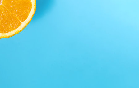 Macro shot of a quarter slice of orange. A quarter of an orange as the sun on a blue backgroundの写真素材