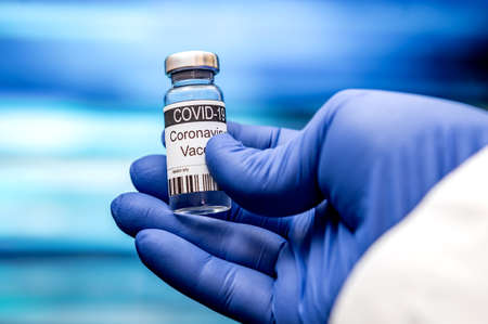 Vaccination. Coronavirus vaccine COVID-19. Coronavirus Vaccine concept in hand of doctor blue vaccine jar. Concept of fight against coronavirus.の写真素材