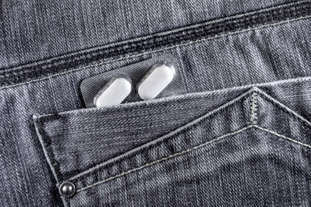 Pills in jeans pocket. Blister pack of white pills in back jeans pocket. Care health conceptの写真素材
