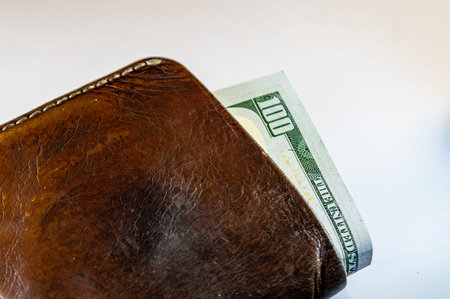 Leather wallet with one hundred dollars. Brown wallet with money close-upの写真素材
