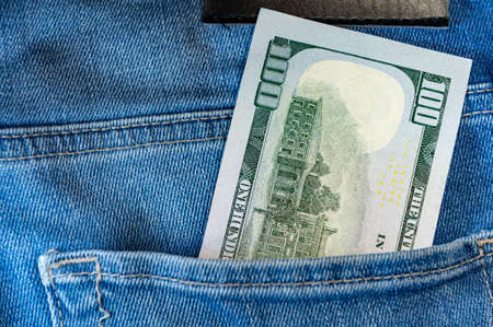 One hundred dollars in jeans pocket. Close up one hundred US Dollar as symbol of poverty and bankruptcy.の写真素材