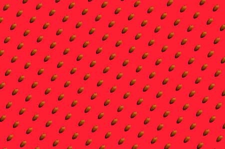 Background from almonds. Trendy sunny pattern of almonds on a bright red background. Colorful...