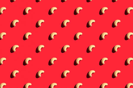Pattern of cashew. Fashionable sunny porridge pattern on a bright red background. Colorful pattern. View from aboveの写真素材