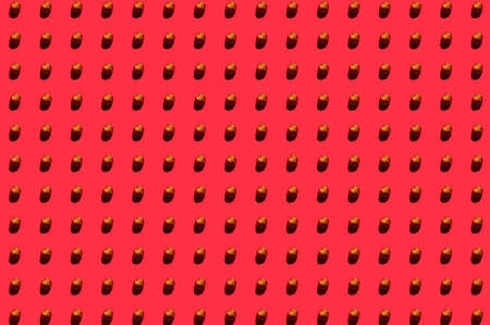 Hazelnuts background. A trendy sunlight pattern made of hazelnuts against a bright red background. Colorful pattern. Top viewの写真素材