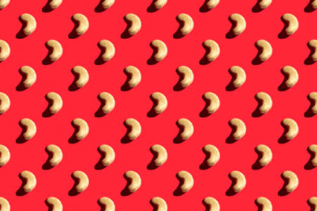 Pattern of cashew. Fashionable sunny porridge pattern on a bright red background. Colorful pattern. View from aboveの写真素材