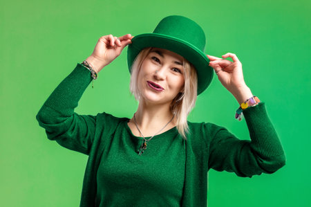 St. Patrick's Day. Beautiful smiling woman wearing green hat. green background