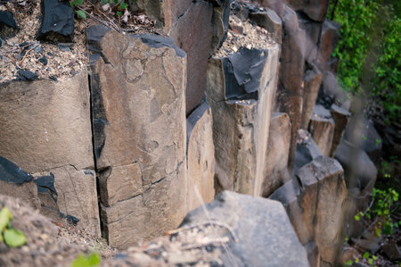 Basalt pillars in an abandoned quarry. Abandoned basalt quarry as a natural monument with exposed...