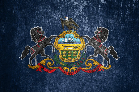 Close-up of the grunge Pennsylvania state flag. Dirty Pennsylvania state flag on a metal surface.の写真素材
