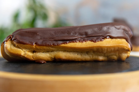 French ecler with chocolate. Traditional French dessert eclair. Chocolate cake with cream
