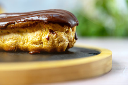 French ecler with chocolate. Traditional French dessert eclair. Chocolate cake with cream