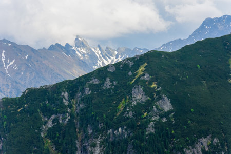The peaks of the Tatra National Park. View from the blue tourist trail leading from Morskie Oko to the valley of Five Ponds. Picturesque clouds over the peaks.の写真素材