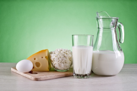 still life of dairy products and cutting boards on a green backgroundの写真素材