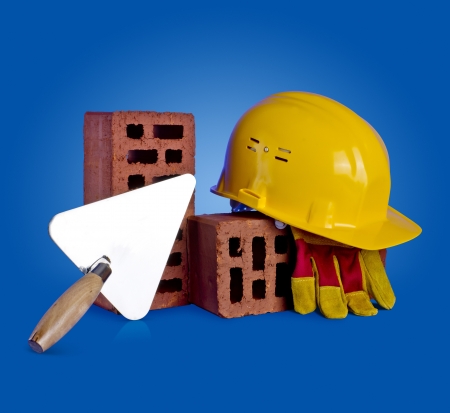 bricks, trowel and helmet on a blue backgroundの写真素材