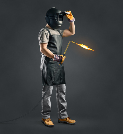 worker welder with gas welding machine on gray backgroundの写真素材