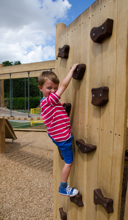 Boy scaling a climbing wallの写真素材