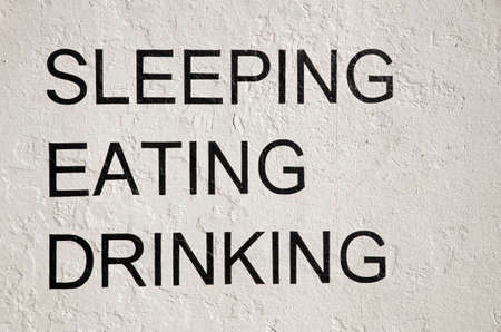 Sleeping, eating, drinking written on wallの写真素材