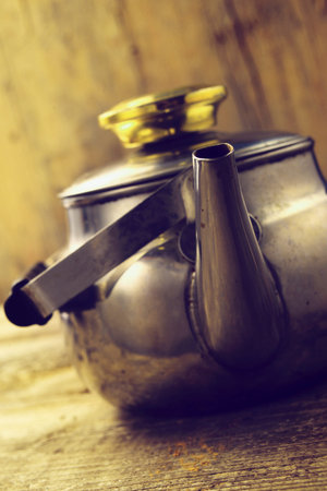 metal tea kettle on wooden background
