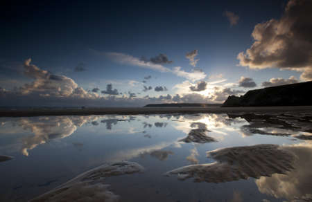 Still conditions turn the water into a mirror, reflecting the sky aboveの写真素材