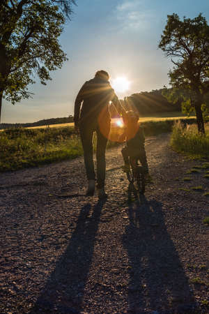 Mon and her child learning to cycleの写真素材