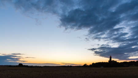 lighthouse at cape arkona at sunset with cloudsの写真素材
