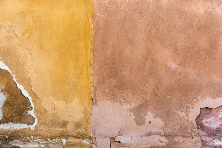 The weathered facades in yellow and beige in closeup