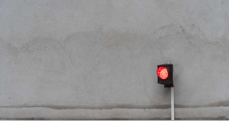 The traffic light shows red on the gray facadeの写真素材