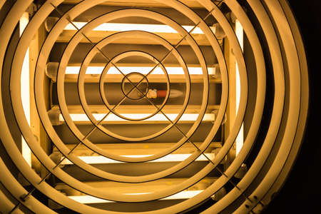 An old light bulb in the middle of fluorescent tubesの写真素材