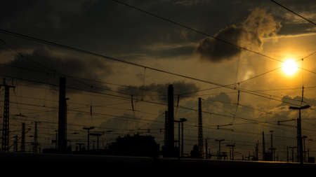Catenary cables cross the sun in the background in the late afternoonの写真素材