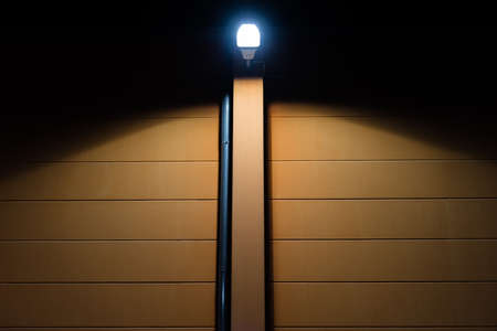 Street lights on the facade of a brown house at nightの写真素材