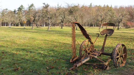 An old rusty mower on a green meadowの写真素材