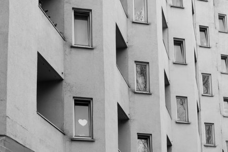 Heart behind the window of an apartment building in black and whiteの写真素材