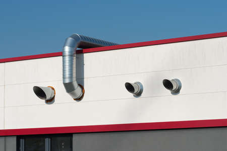 Stainless steel air ducts on a red roofの写真素材