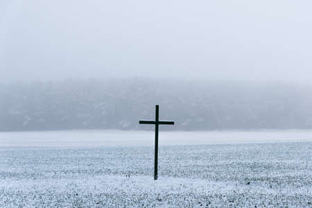 Big black cross on a field in winterの写真素材