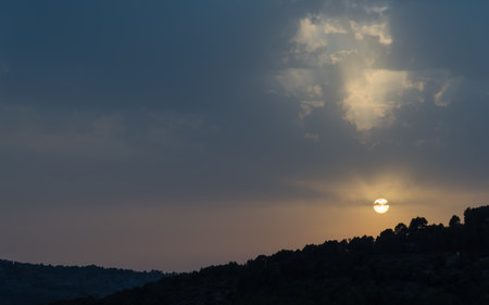 The sun over the mountains near Sollerの写真素材