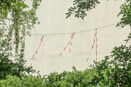 Barrier tape on a line in front of a house facade with green borderの写真素材
