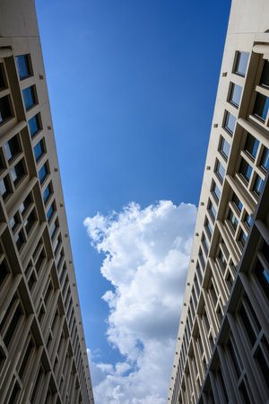 Two house fronts facing each other with blue sky and cloudsの写真素材